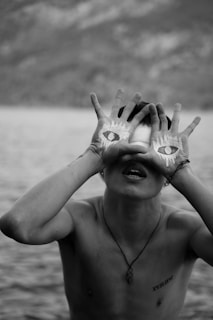 a man holding his hands up to his eyes