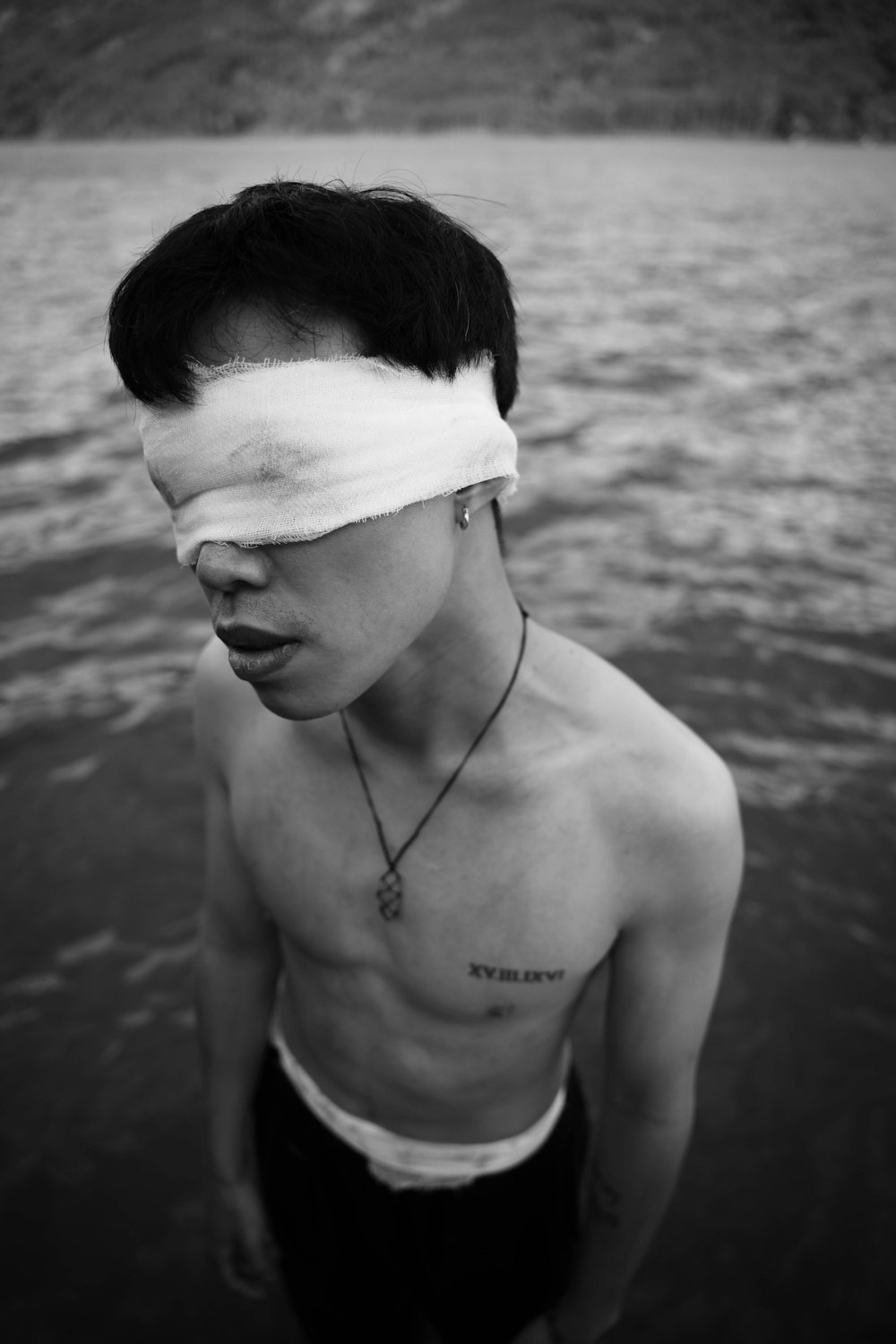 a man with a blindfold on his face standing in the water