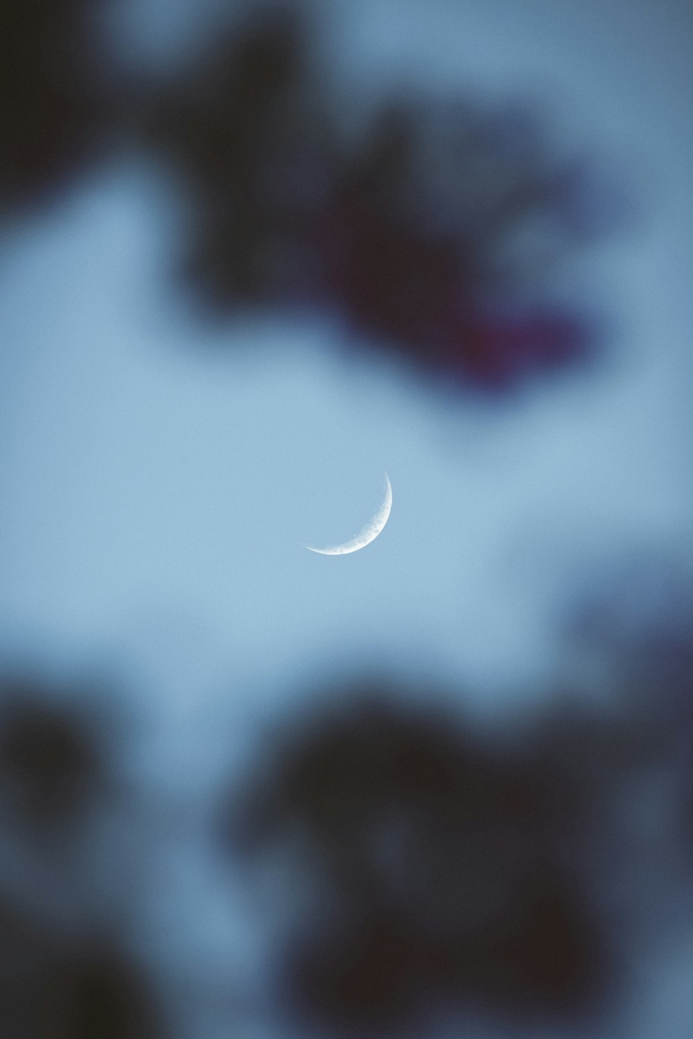 the moon is seen through the clouds in the sky