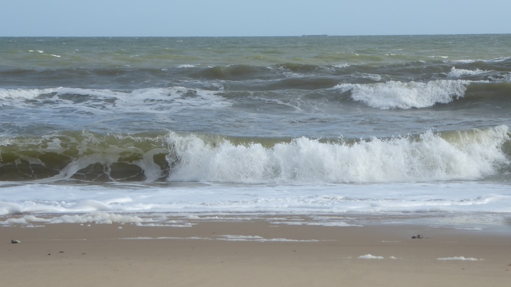 a person standing on a beach with a surfboard