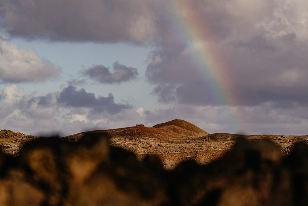 a rainbow in the sky over a mountain range