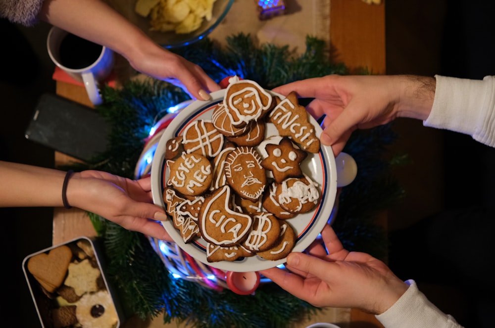 a group of people holding a plate of cookies