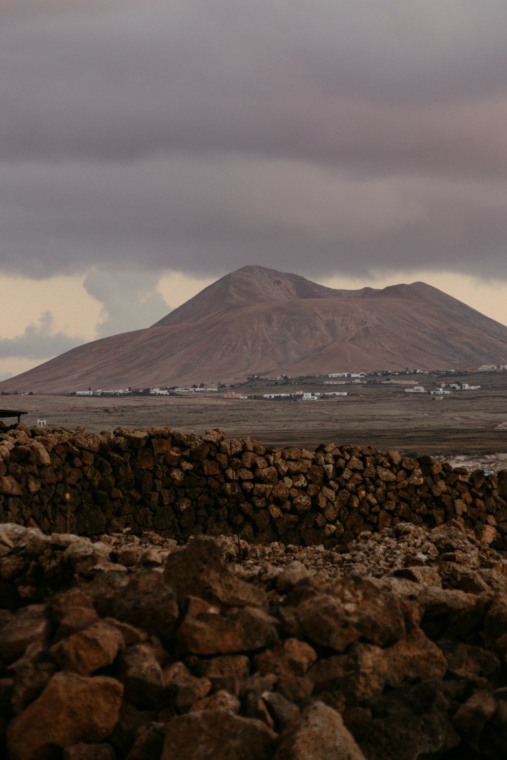 a stone wall with a mountain in the background