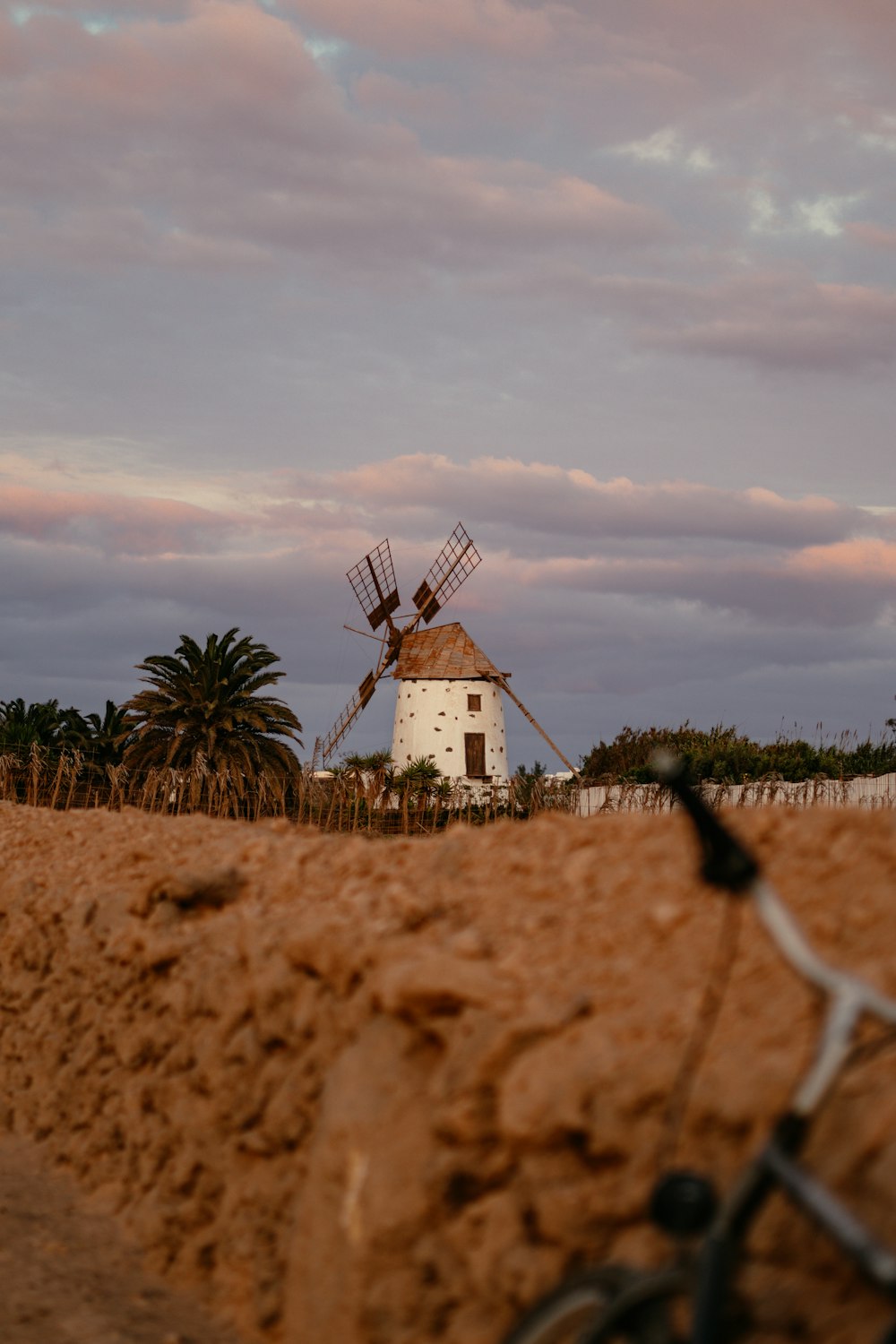 a bike leaning against a wall with a windmill in the background