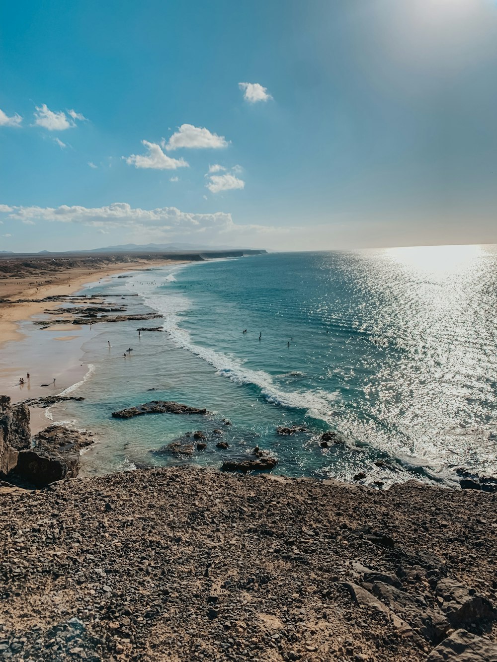 a view of a beach with people swimming in the water