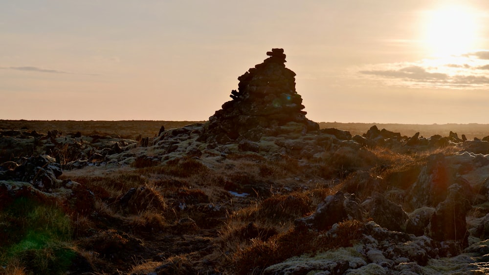 the sun is setting over a rocky outcropping