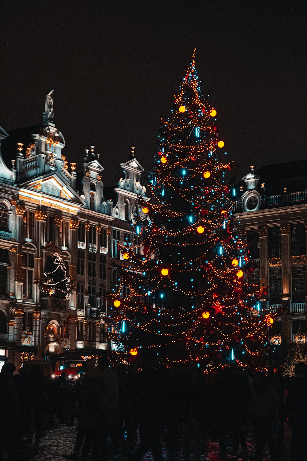 a lit christmas tree in front of a building