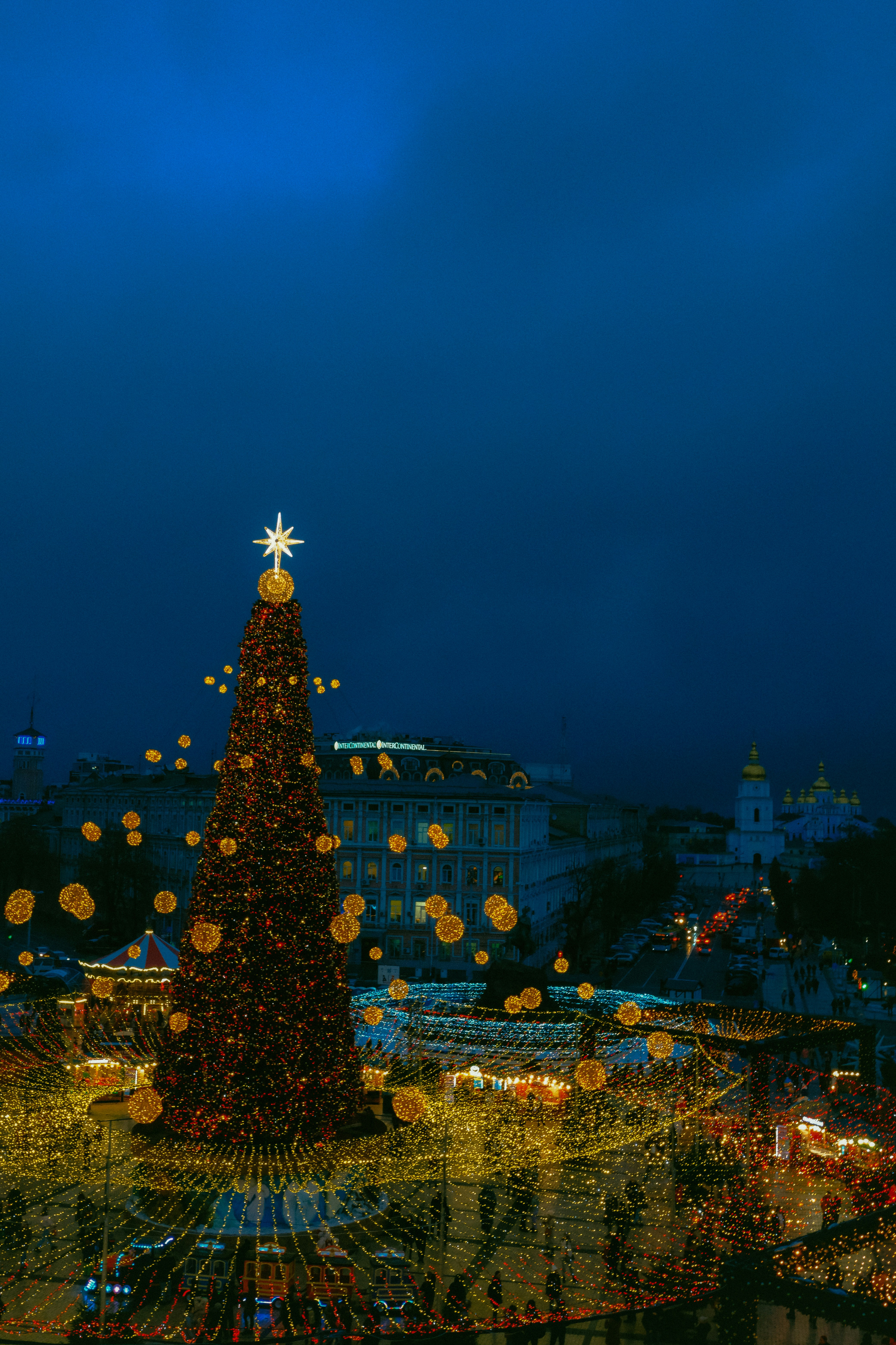 a large christmas tree is lit up at night