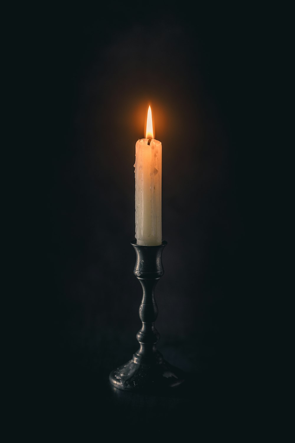 a single candle is lit in the dark