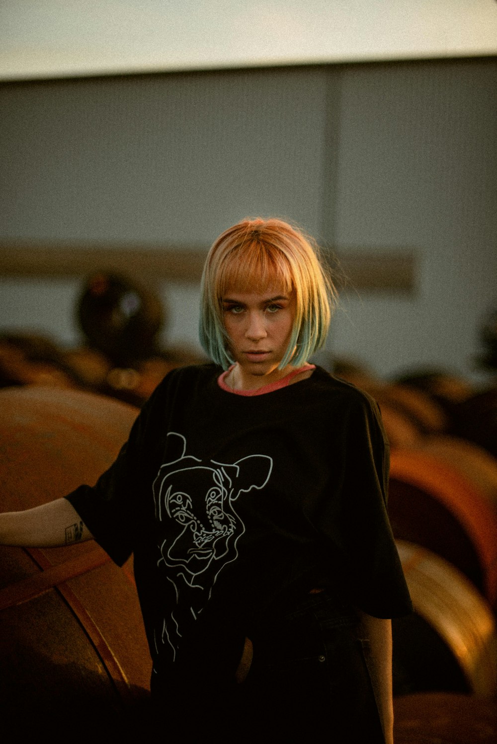 a girl with blonde hair standing in front of a barrel