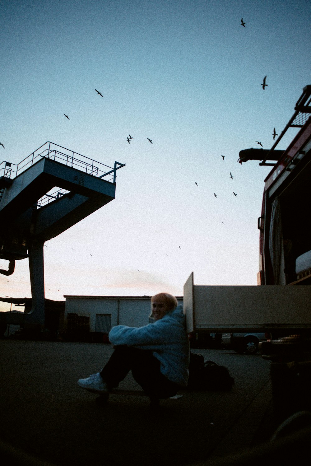 a man sitting on the ground in front of a building