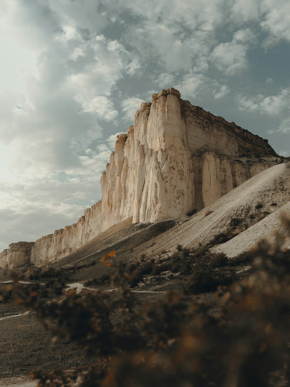 a rocky mountain with a cloudy sky in the background