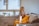 a woman sitting on a couch holding a glass of water