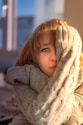 a little girl wearing a sweater and a scarf