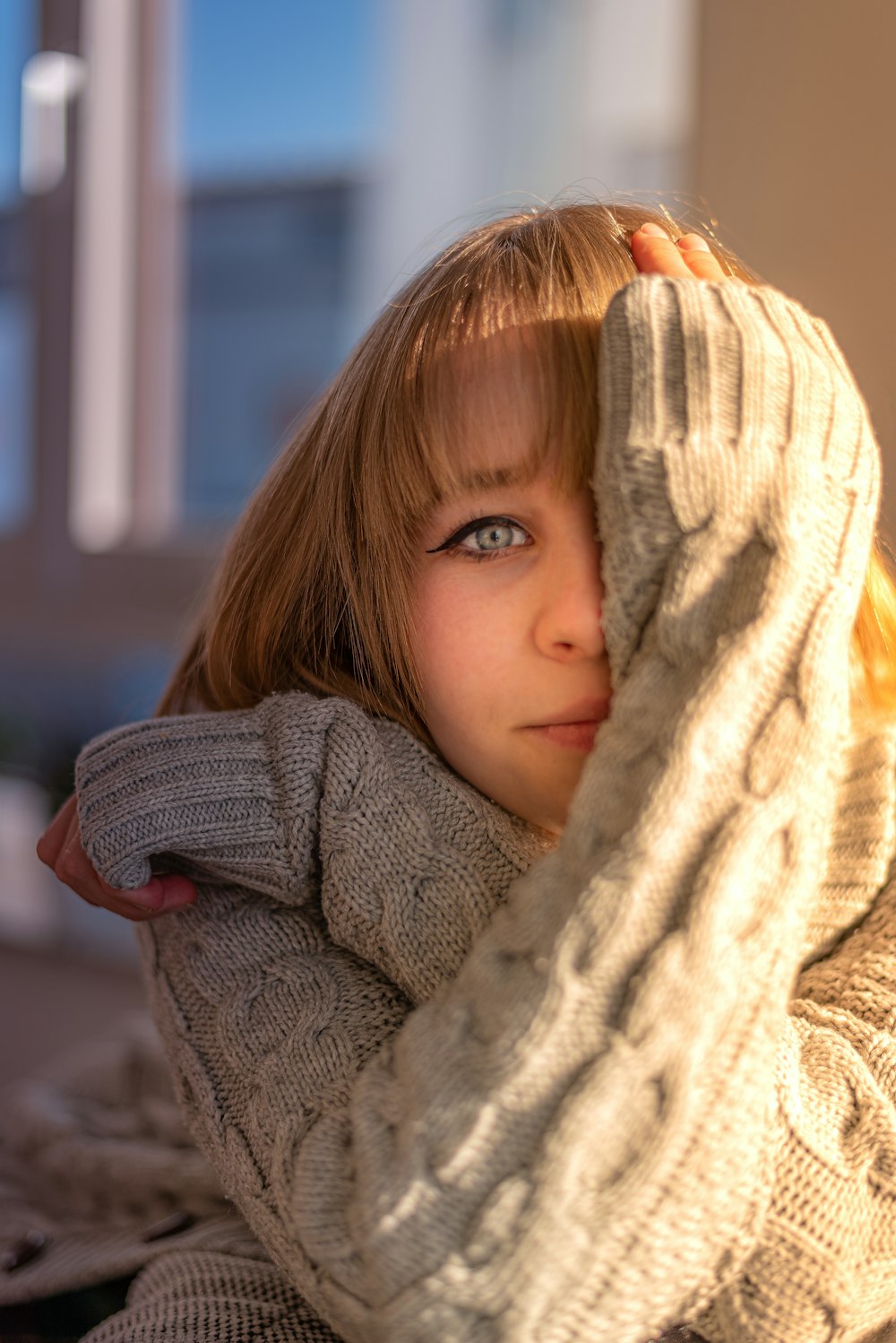 ein kleines Mädchen mit Pullover und Schal