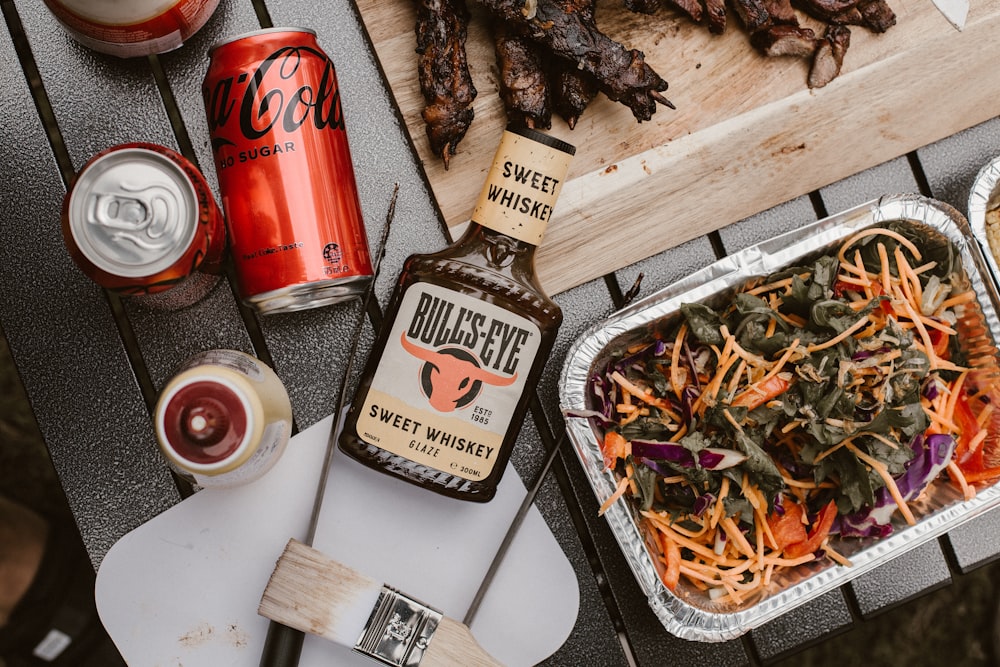 a table topped with a tray of food and a bottle of booze