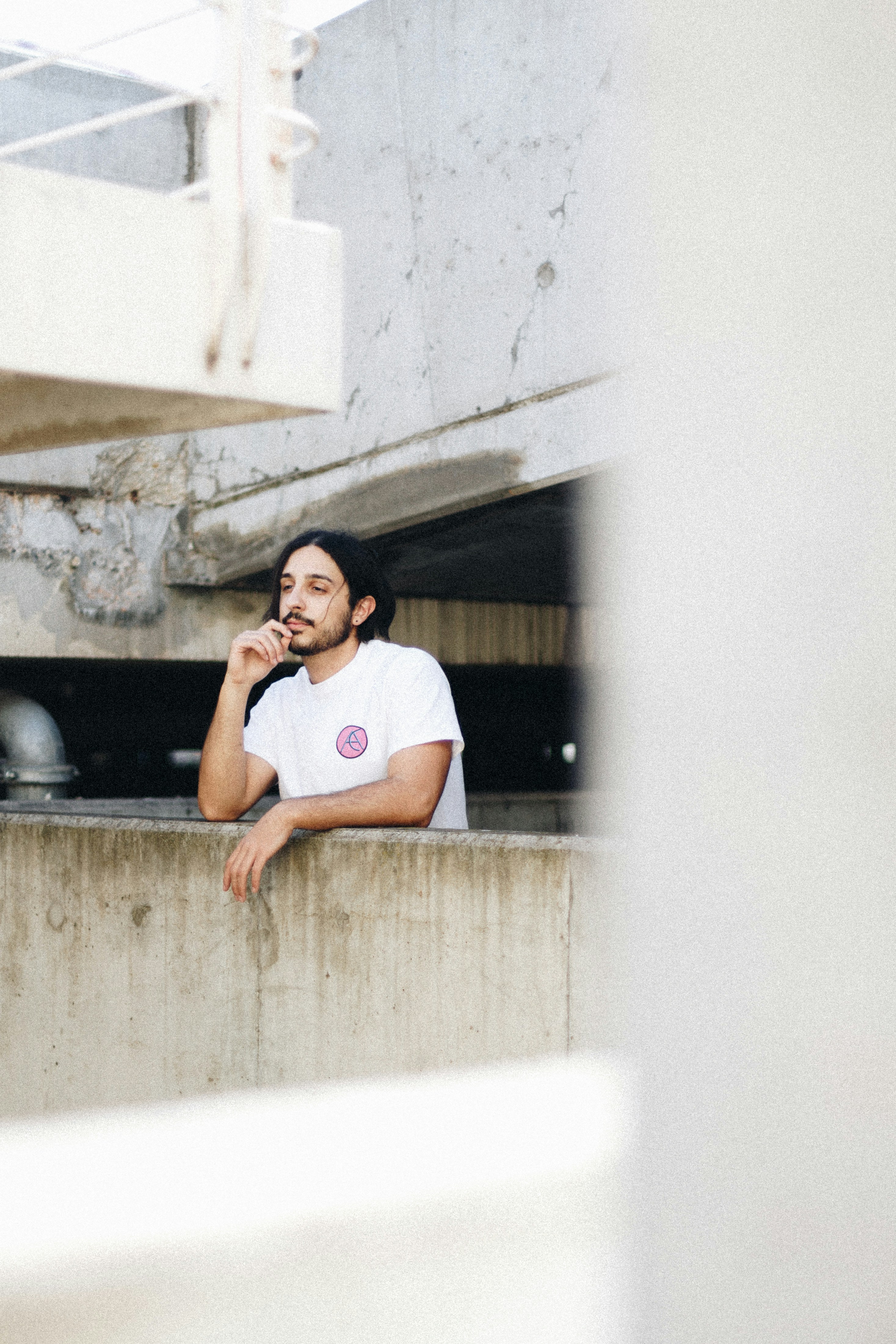 a man leaning against a wall talking on a cell phone