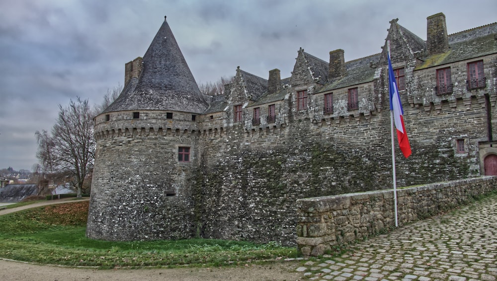 a castle with a flag on a cobblestone road