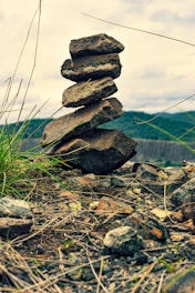 a pile of rocks sitting on top of a grass covered field