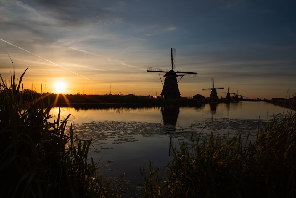 un moulin à vent assis au-dessus d’un plan d’eau