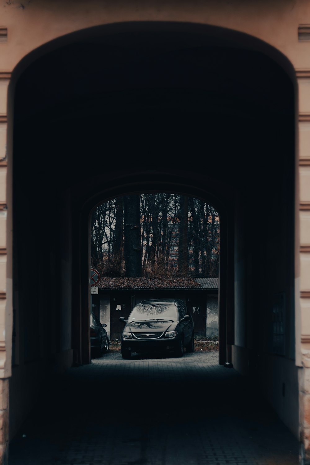a car is parked in a tunnel between two buildings