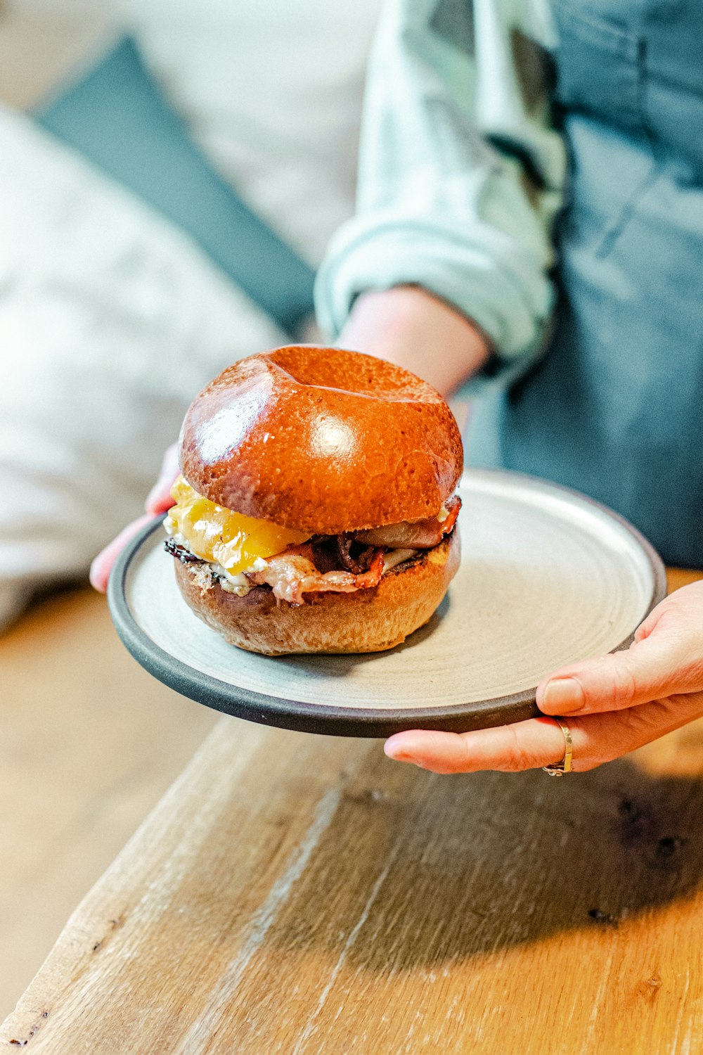 a person holding a plate with a hamburger on it