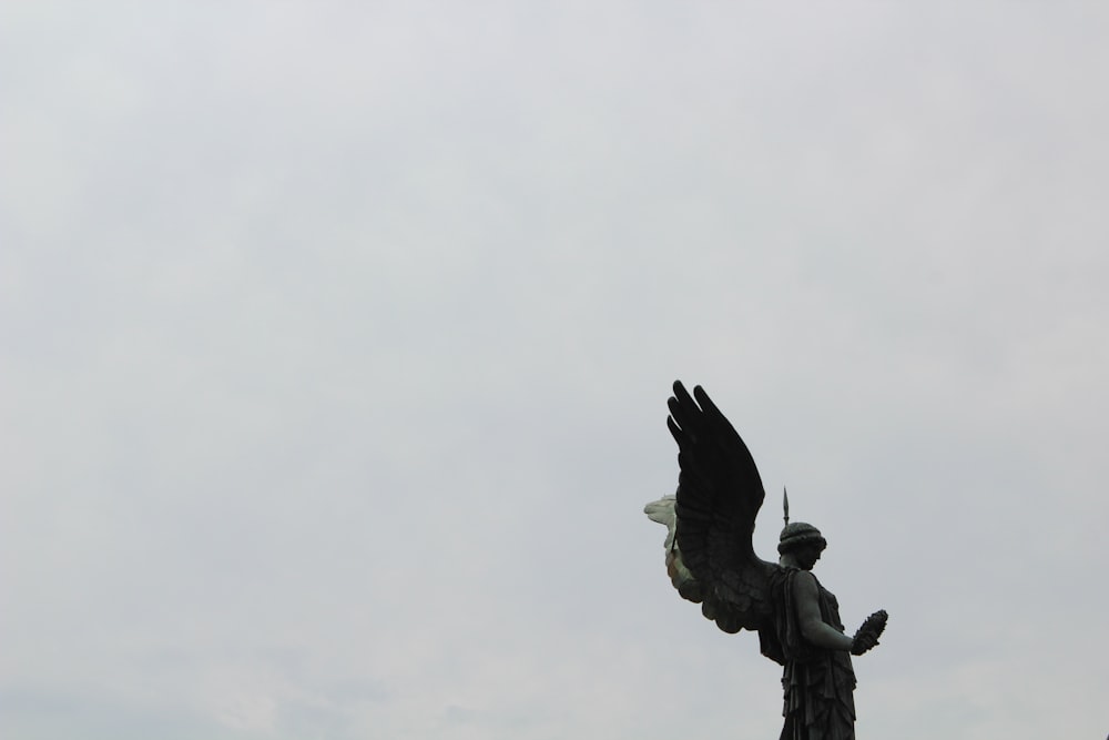 Una estatua de un hombre sosteniendo un pájaro en sus manos