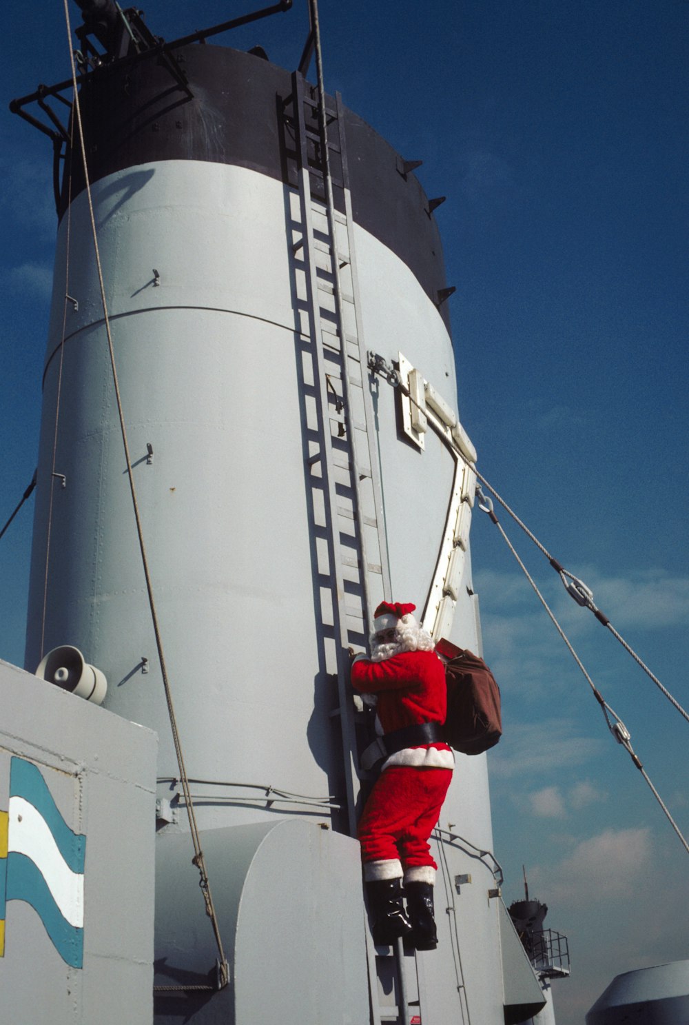 a man in a santa suit climbing up a ladder