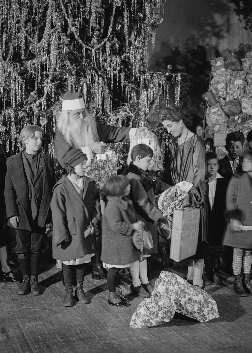 a group of people standing around a christmas tree