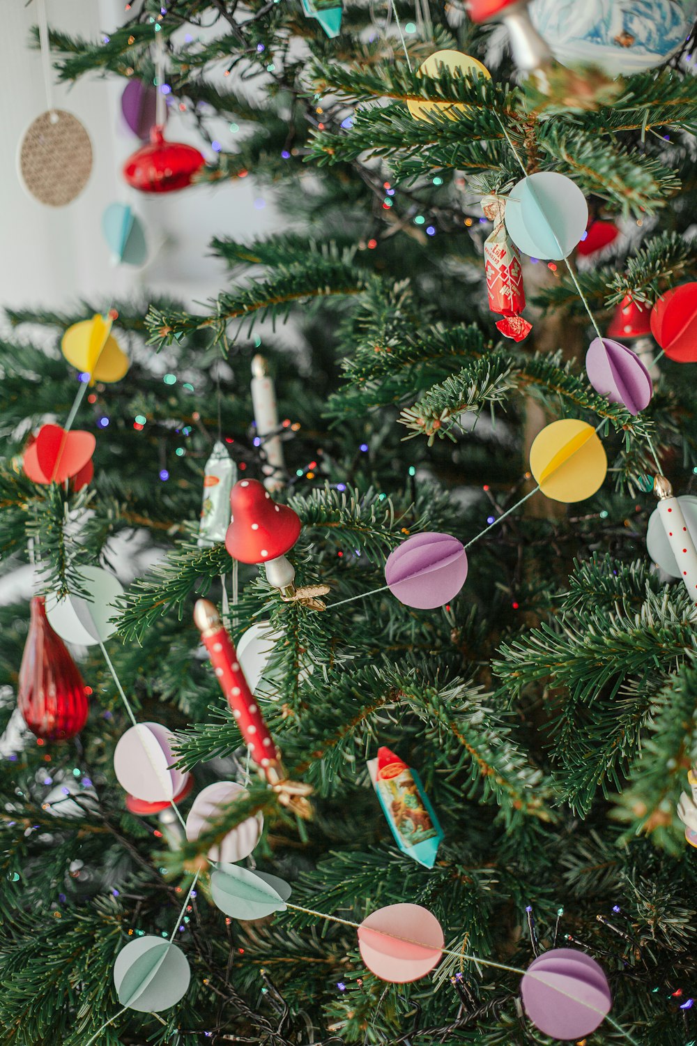 uma árvore de Natal decorada com enfeites de papel coloridos