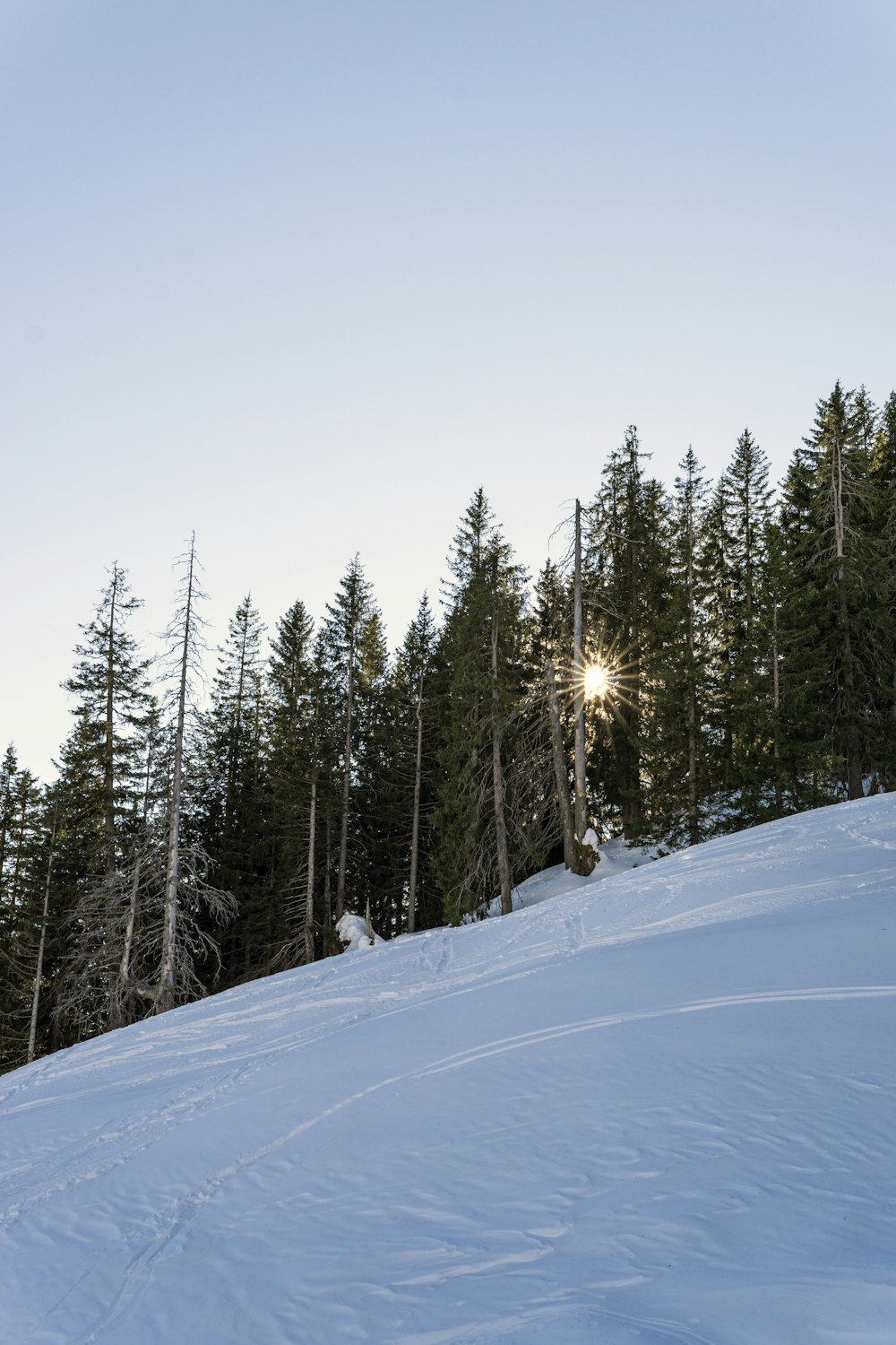 a person riding a snowboard down a snow covered slope