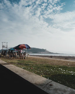 Smiling guests enjoying a break by the seaside seating area, with ocean waves in the background.