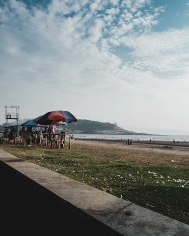 Smiling guests enjoying a break by the seaside seating area, with ocean waves in the background.