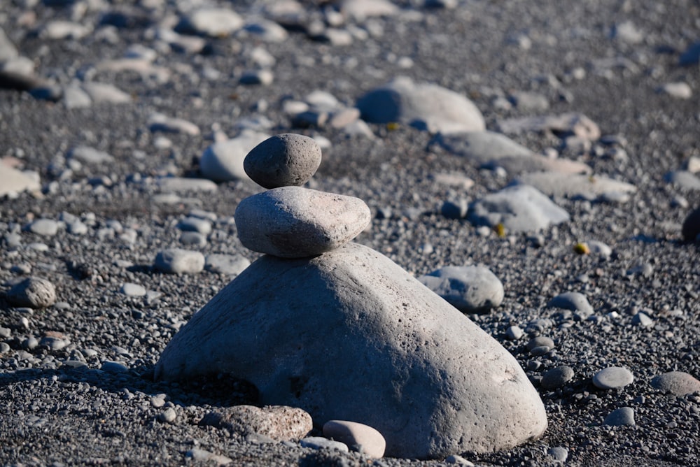 a pile of rocks sitting on top of a sandy beach