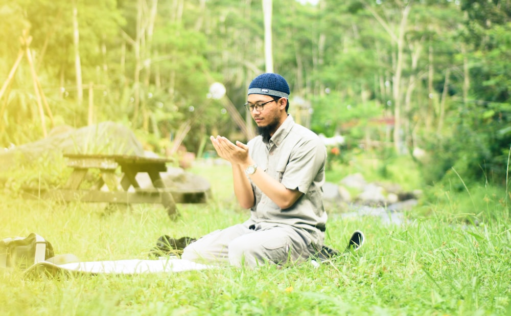 a man sitting in the grass praying