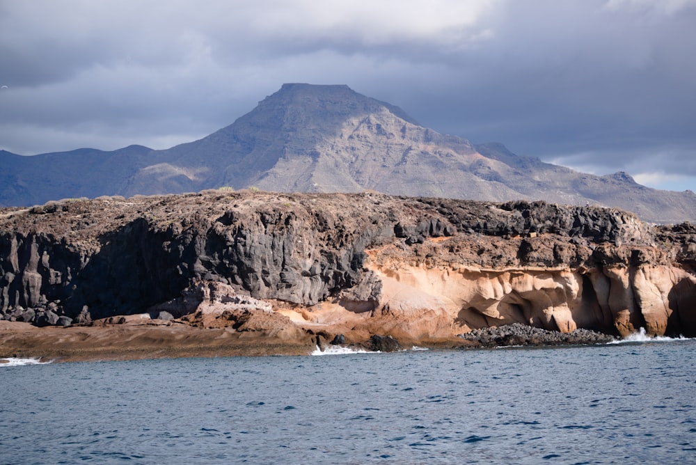 a large mountain with a large body of water in front of it