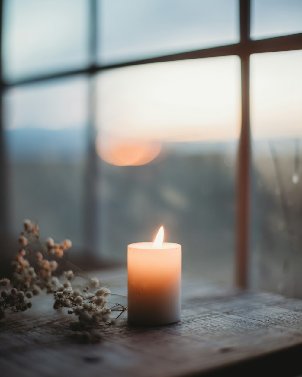 a lit candle sitting on top of a wooden table