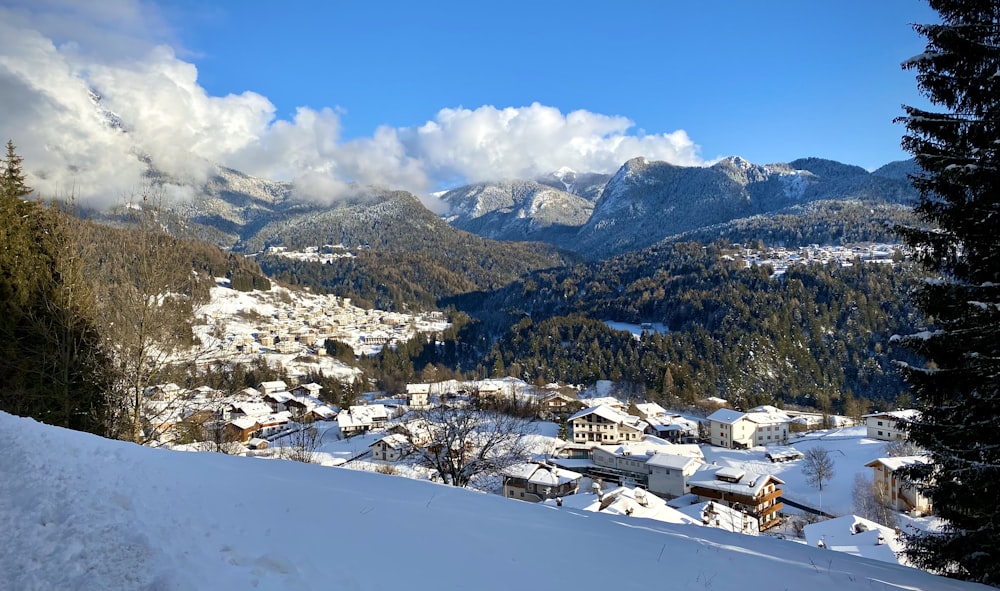 a view of a town in the mountains covered in snow