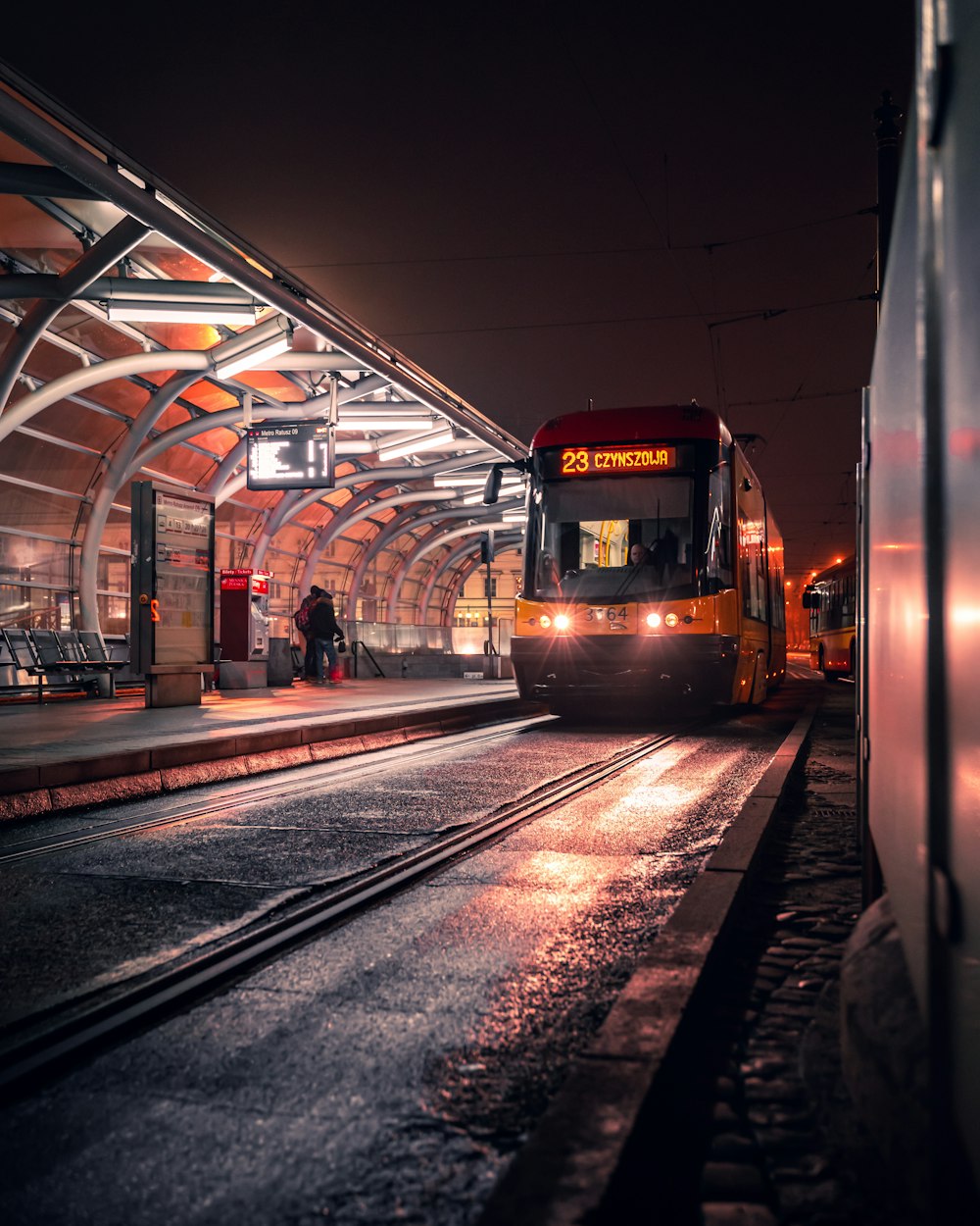 a train pulling into a train station at night