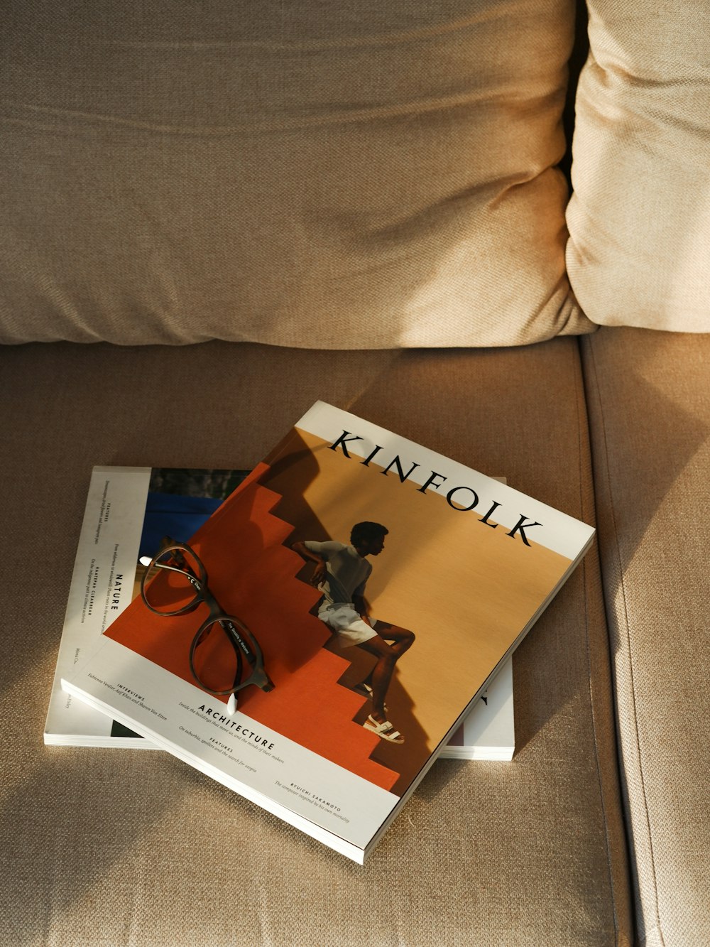 a book sitting on top of a couch next to a pillow