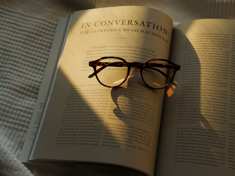 an open book with a pair of glasses on top of it