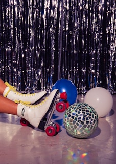 Close-up of colorful roller skates lined up on a wooden floor inside a skating rink.