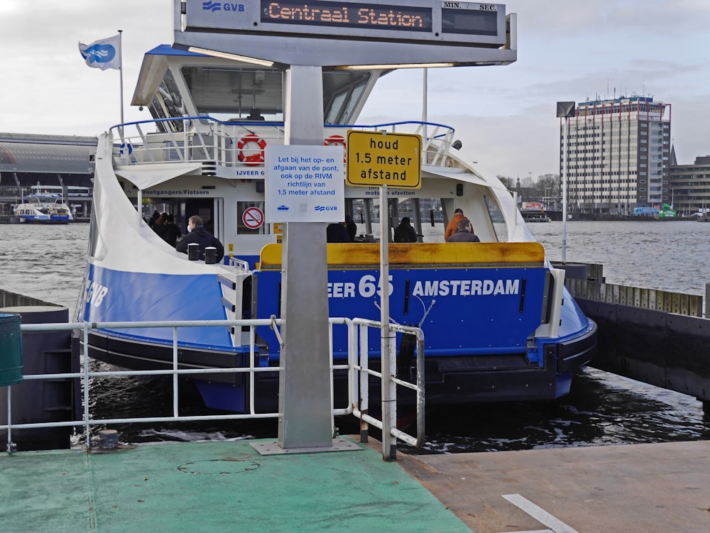 a blue and white boat docked at a pier