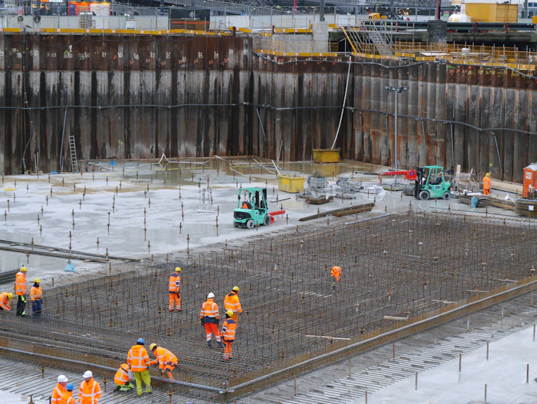 A large foundation slab being poured with a crew on site.