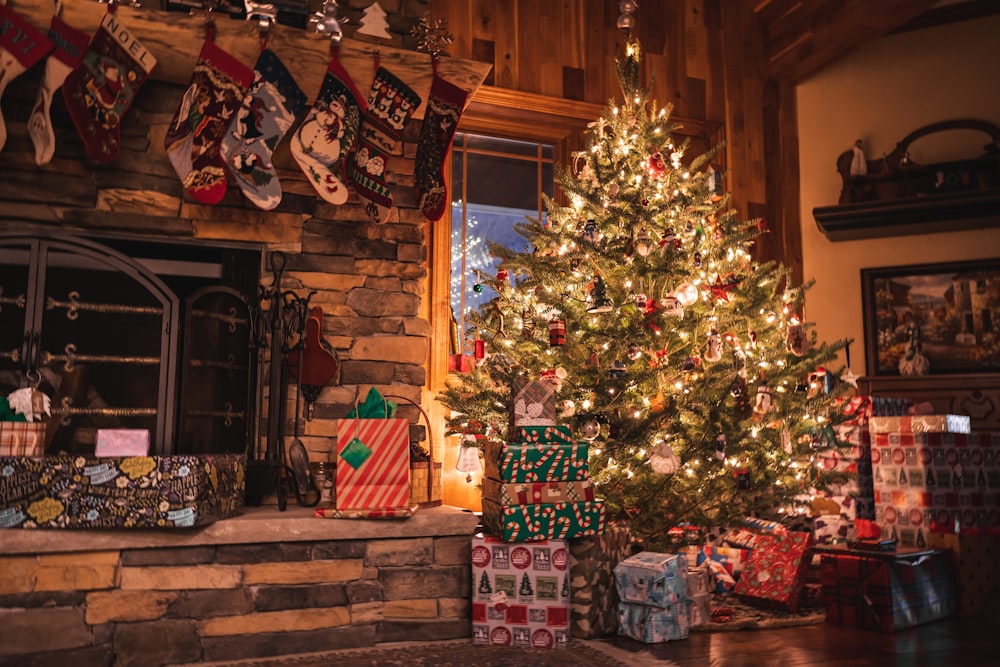 a decorated christmas tree in front of a fireplace