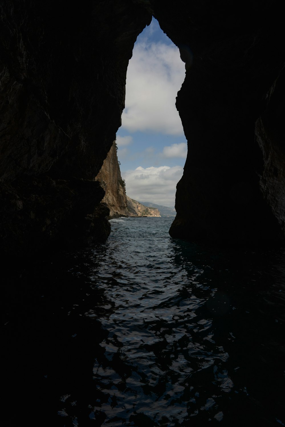 a view of a body of water through a cave