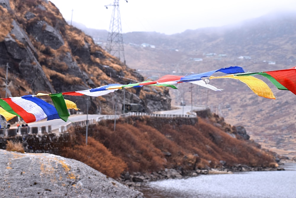 a group of colorful flags hanging over a body of water