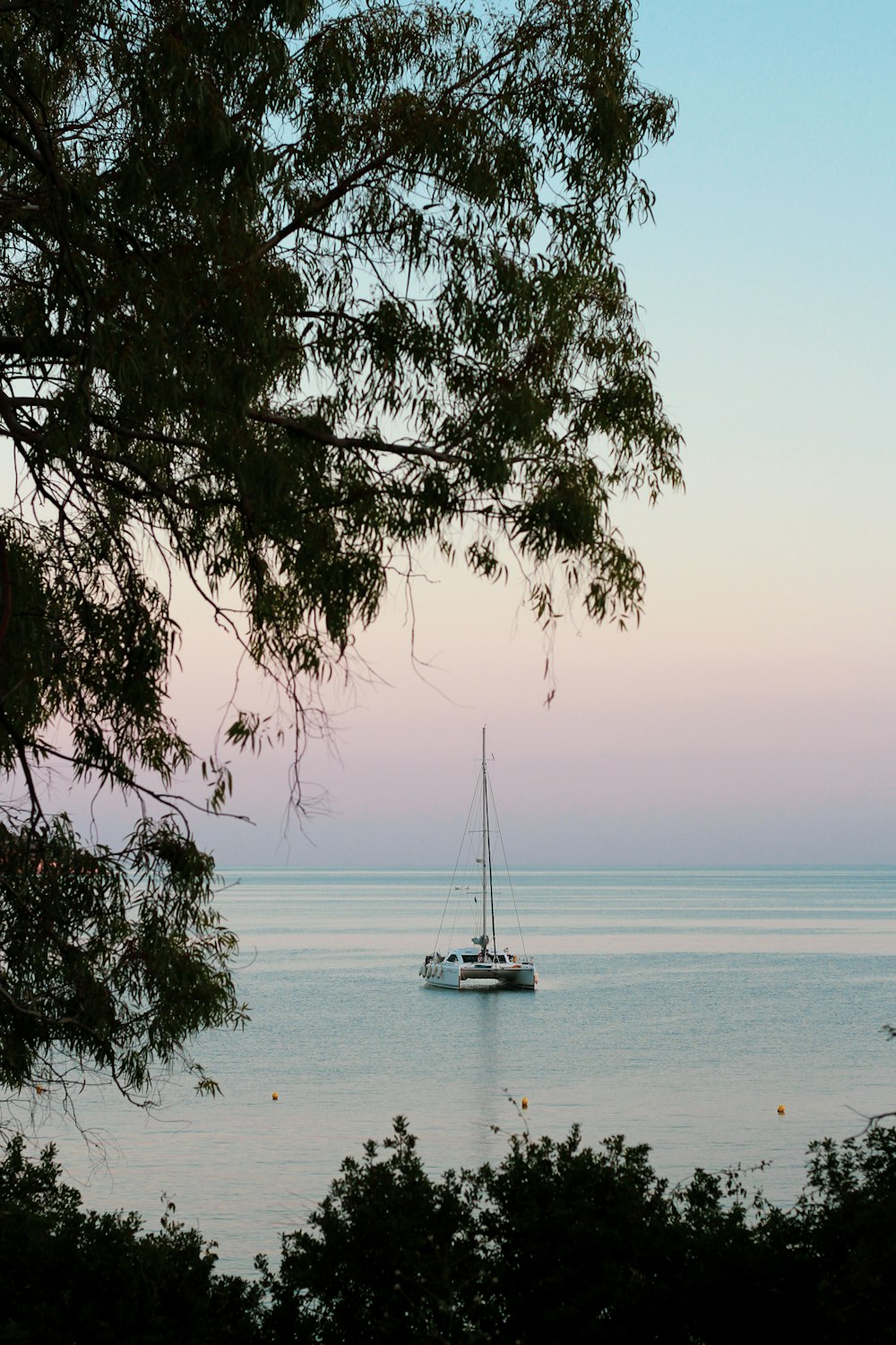 a sailboat is out on the water at sunset