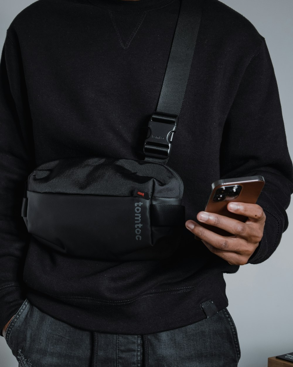 a man holding a cell phone and a fanny bag