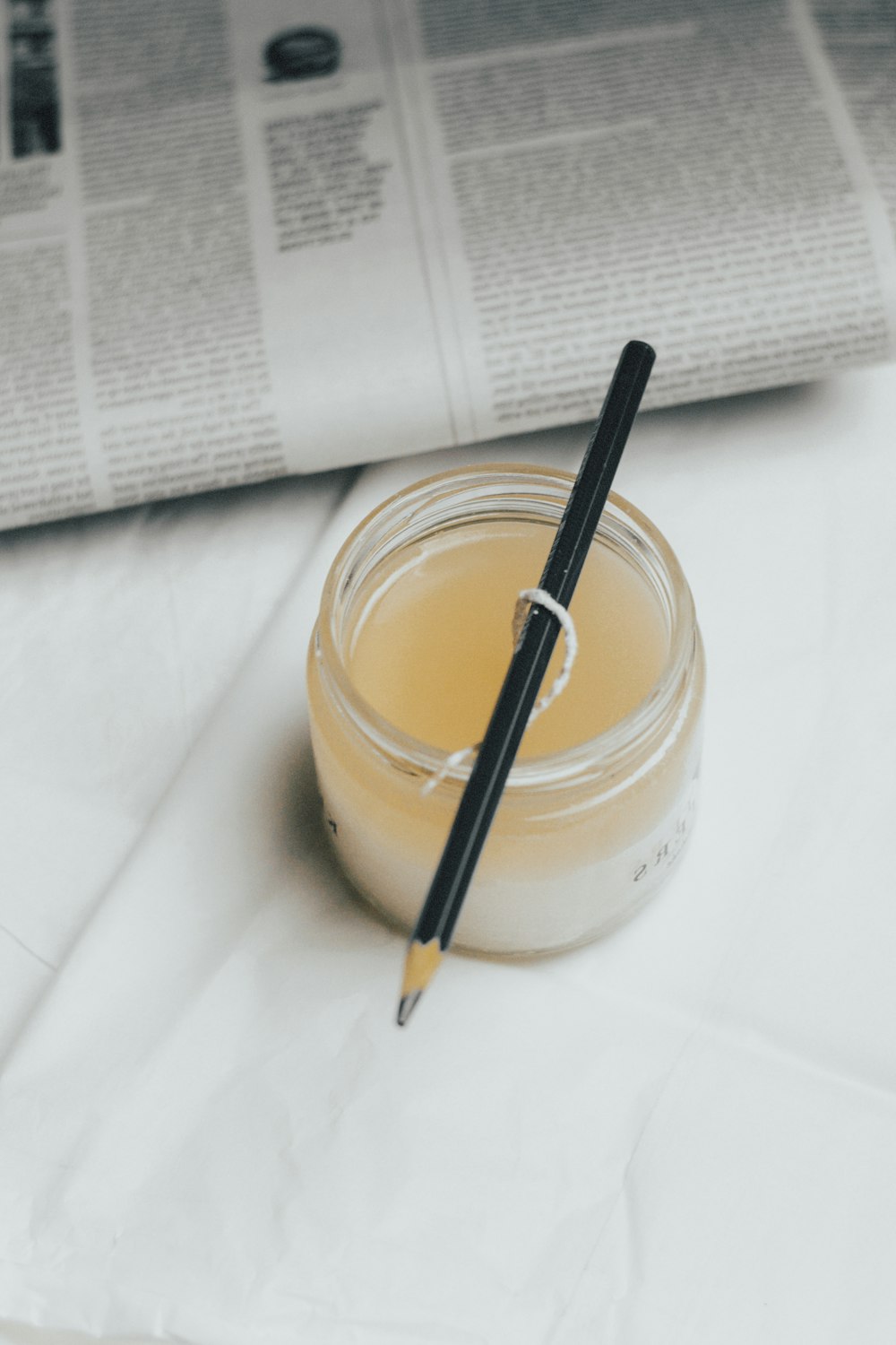 a jar of liquid with a pen on top of it